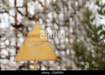Rostiger nuklearer Gefahrenschild vor dem Duga-System, einem Sowjet am Horizont im Tschernobyl-Sperrgebiet. Stockfoto