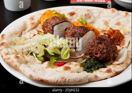 Indisches ethnisches Essen Keema Kofta (Fleischbällchen) auf Naan-Brot Stockfoto