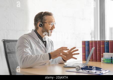 Arzt mittleren Alters während einer Online-Konsultation mit einem Patienten. Das Konzept des Gesundheitswesens und moderne Technologien in der Medizin. Stockfoto