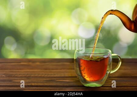 Tee aus der Teekanne in die Tasse gießen Stockfoto