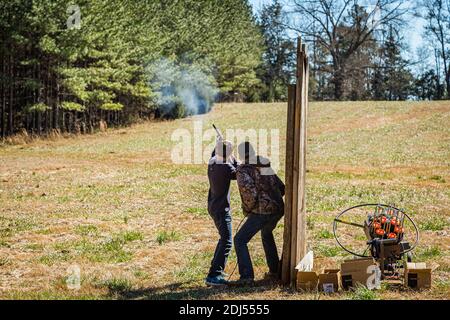 Woodland, GA / USA - 13. Februar 2016: Ein Jugendlicher erhält eine Sicherheits- und Verfahrensschulung durch einen erwachsenen Mentor, während er die Verwendung von Schusswaffen praktiziert. Stockfoto