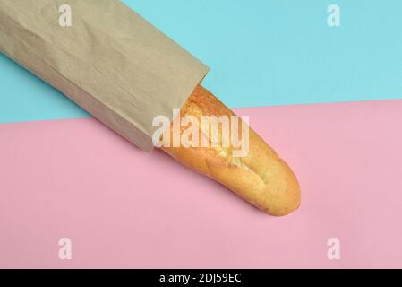 Französisches Baguette auf pastellfarbenem Hintergrund. Minimalistischer Trend. Draufsicht. Stockfoto