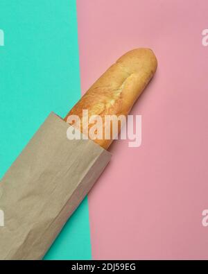 Französisches Baguette auf pastellfarbenem Hintergrund. Minimalistischer Trend. Draufsicht. Stockfoto