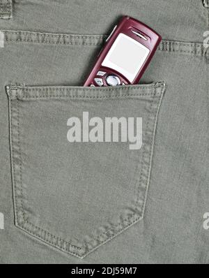 Veraltete Taste Telefon mit einem Bildschirm für Kopierer Platz in der Gesäßtasche von grünen Jeans. Stockfoto