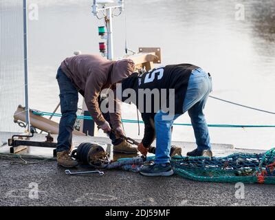 Fischer reparieren Netze am Bideford Quay, Devon, Großbritannien Stockfoto