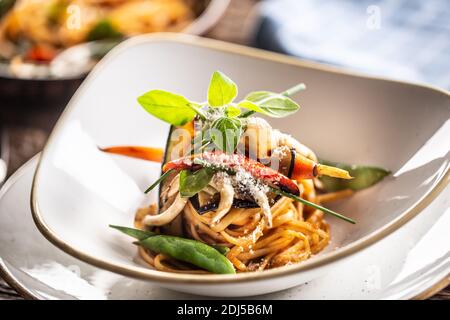 Vegetarische Linguini-Pasta mit Aubergine, grünen Erbsen, Karotte, Pfeffer und Basilikum. Stockfoto