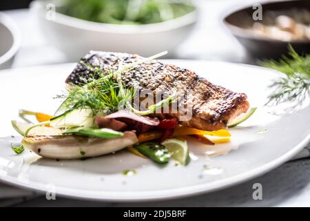 Professionell überzogenen gegrillten Fisch mit Haut auf gegrillten Vegtables mit Kalk serviert. Stockfoto