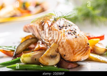 Gesund gekochter norwegischer Lachs serviert mit gegrilltem Gemüse und Pilzen. Stockfoto