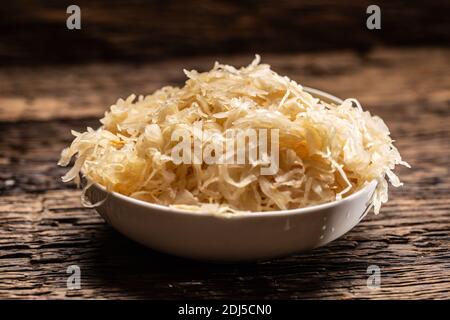 Eine Schüssel voller roher Sauerkraut-Kohlensauce auf einer rustikalen dunklen Oberfläche. Stockfoto