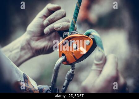 Nahaufnahme der Hände eines Mannes, der eine Klettervorrichtung bediente. Stockfoto