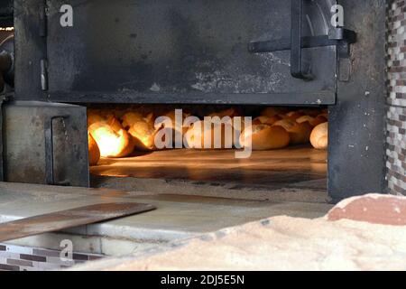 Ein großer klassischer Holzofen, der Brot, Holzofen und gebackenes Brot backt, Stockfoto