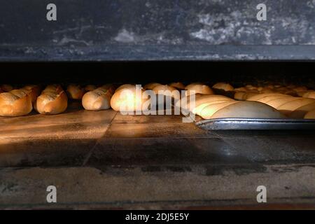 Ein großer klassischer Holzofen, der Brot, Holzofen und gebackenes Brot backt, Stockfoto