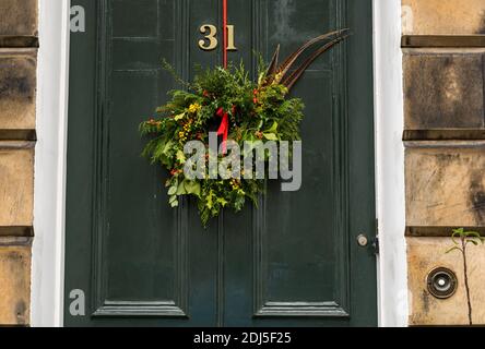 Dekorativer Weihnachtskranz an getäfelter Eingangstür 31 des georgianischen Stadthauses, Edinburgh New Town, Schottland, Großbritannien Stockfoto