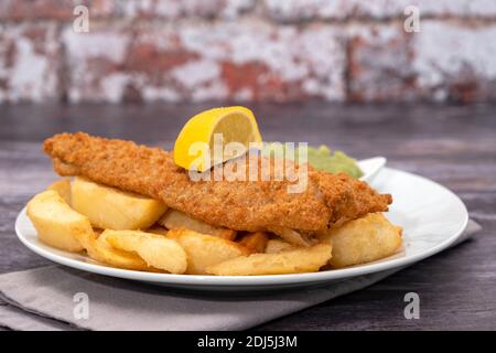 Gebratener panierter Kabeljau mit pommes Frites und matschigen Erbsen Stockfoto