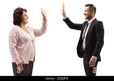 Ältere Frau gestikuling High-five mit einem jungen Mann in einem Anzug isoliert auf weißem Hintergrund Stockfoto