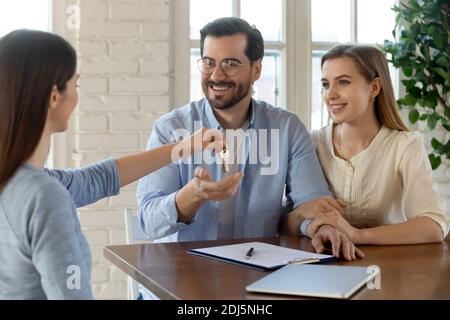 Makler geben Schlüssel zu aufgeregt paar Käufer Stockfoto