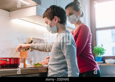 Mutter und Sohn kochen zu Hause während der Krisenzeit Stockfoto