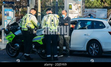 Madrid, Spanien - 12. Dezember 2020: Verkehrspolizei spricht mit einem Taxifahrer Madrid, Spanien Stockfoto