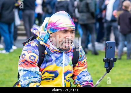 Manchester Sa 12. Dezember 2020. Freiheitsdemonstration/Anti-COVID-19-Beschränkungen Protest, Piccadilly Gärten. Ein bunt gekleideter Proster-Livestreaming Stockfoto