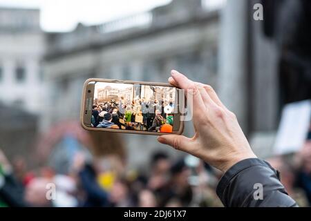 Manchester Sa 12. Dezember 2020. Freiheitsdemonstration/Anti-COVID-19-Beschränkungen Protest, Piccadilly Gärten. Eine Person, die ihre Smartphone-Aufnahme hält Stockfoto