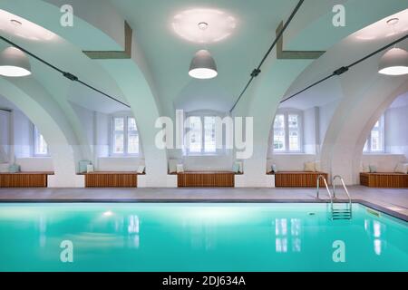 Luxus Resort Swimmingpool mit vielen Fenstern mit wunderschönem sauberen blauen Wasser und schönen Lichteffekten. Hallenbad im Wellness-Bereich des Hotels Stockfoto