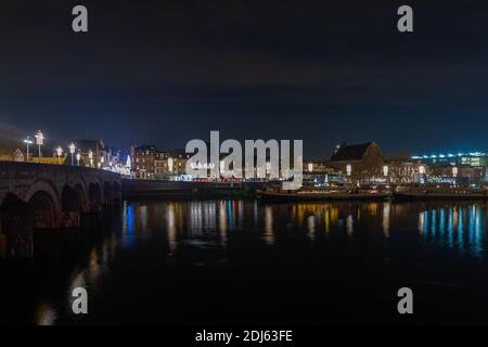 Beleuchtete Skyline von Maastricht geschmückt zu Weihnachten mit Reflexionen in Die Maas und die römische Sint Servaas Brücke gesehen Aus Richtung Wyck Stockfoto