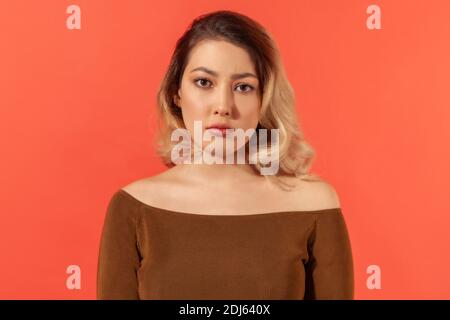 Porträt einer unglücklich depressiven jungen Frau mit blonden Haaren in brauner Bluse Blick auf die Kamera. Ihr Gesicht drückt Müdigkeit und Druck aus. Innen i Stockfoto