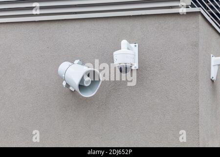 Outdoor-Megaphon-Überwachungskamera an der Wand des Gebäudes. Lautsprecher und überwachungskamera. Stockfoto