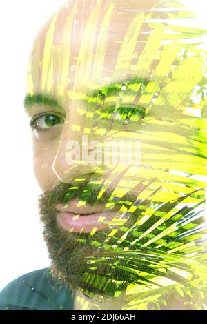 Ein bärtiger Mann und Palmenblätter Foto doppelt Aufnahme Porträt Nahaufnahme Stockfoto