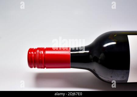 Nahaufnahme der Oberseite und des Halses einer Flasche Rotwein mit Schraubverschluss auf einem schlichten weißen Hintergrund. Keine Personen. Speicherplatz kopieren. Stockfoto