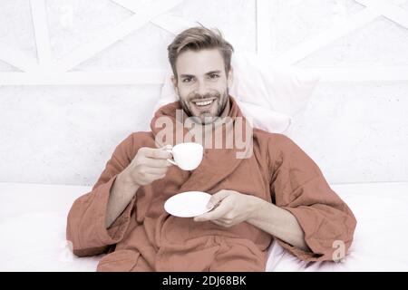 Kaffee am Morgen genießen. Gerne morgen. Schöner Mann trinken Kaffee am Morgen. Happy bärtiger Mann im Bett. Gute Laune. Ab Tag mit guten Kaffee. Entspannt zu Hause. Angenehme Momente. Gourmet Espresso. Stockfoto