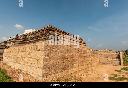 Hampi, Karnataka, Indien - 4. November 2013: Eckansicht von Mahanavami Dibba oder der Dussehra-Plattform. Braune Steine mit Skulpturen unter blauer Wolkenstein Stockfoto