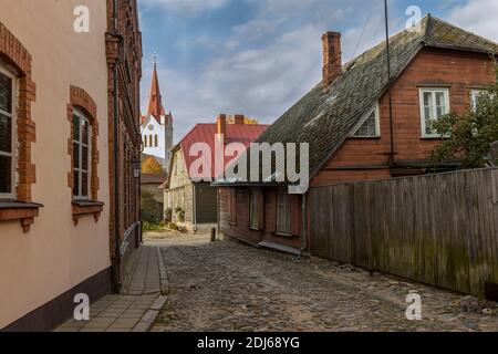 Leere Kopfsteinpflaster und den Kirchturm in der kleinen Stadt Cesis, Lettland Stockfoto