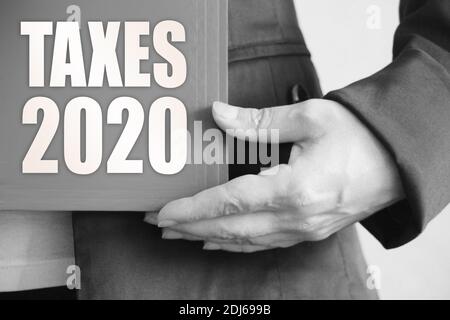 Steuern 2020 Wörter auf dem Umschlag von Ordner n Geschäftsfrau Hände. Gebühren Geschäftskonzept. Stockfoto