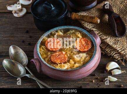 Weihnachts-Kohlsuppe in Keramikschale auf natürlichem Holzhintergrund. Stockfoto