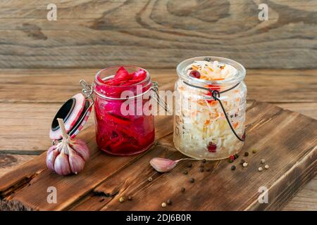 Einmachgläser für Sauerkraut. Hausgemachtes Sauerkraut mit Karotte und Salat-Kohl mit Rote Bete auf einem Holztisch. Fermentierte Lebensmittel Stockfoto