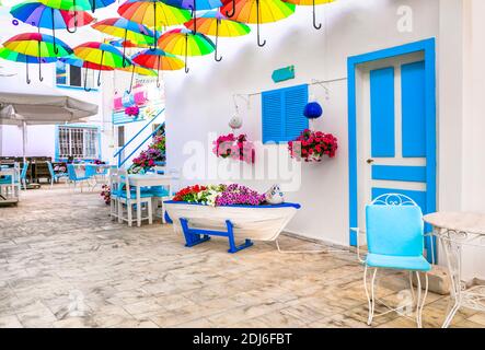 Schöne Straßenbar (Restaurant) Dekoration mit bunten Sonnenschirmen, alten Holzboot und Blumen. Bodrum, Türkei Stockfoto