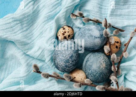 Blaue Ostereier auf blauem Grund. Natürlich mit Hibiskus bemalte Eier mit Marmorsteineffekt. ECO-Farbe. Frohe Ostern Karte. Stockfoto