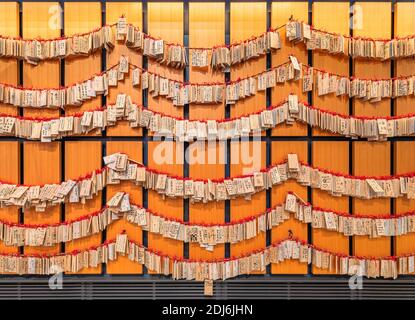 tokio, japan - januar 02 2020: Schintohölzer mit Flugscheinen und handgeschriebenen Gebeten von Gläubigen an der Wand von Omatsur Stockfoto