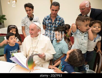 Papst Franziskus hatte am 11. August 2016 mit einer Gruppe von 21 syrischen Flüchtlingen in der Casa Santa Marta, Vatikan, zu Mittag gegessen. Beim Mittagessen hatten sowohl Erwachsene als auch Kinder die Möglichkeit, mit Papst Franziskus über die Anfänge ihres Lebens in Italien zu sprechen. Die Kinder gaben dem Heiligen Vater eine Sammlung ihrer Zeichnungen, und der Papst überschüttete sie mit Spielzeug und anderen Geschenken. Die Flüchtlinge, die in Rom leben und von der Gemeinschaft St. Egidio empfangen werden, wurden von Lesbos nach Rom gebracht, als Papst Franziskus am 16. April 2016 seinen Besuch auf der griechischen Insel ablegte. Die erste Gruppe kam mit t nach Rom Stockfoto