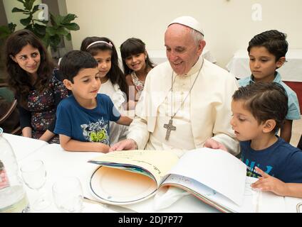 Papst Franziskus hatte am 11. August 2016 mit einer Gruppe von 21 syrischen Flüchtlingen in der Casa Santa Marta, Vatikan, zu Mittag gegessen. Beim Mittagessen hatten sowohl Erwachsene als auch Kinder die Möglichkeit, mit Papst Franziskus über die Anfänge ihres Lebens in Italien zu sprechen. Die Kinder gaben dem Heiligen Vater eine Sammlung ihrer Zeichnungen, und der Papst überschüttete sie mit Spielzeug und anderen Geschenken. Die Flüchtlinge, die in Rom leben und von der Gemeinschaft St. Egidio empfangen werden, wurden von Lesbos nach Rom gebracht, als Papst Franziskus am 16. April 2016 seinen Besuch auf der griechischen Insel ablegte. Die erste Gruppe kam mit t nach Rom Stockfoto