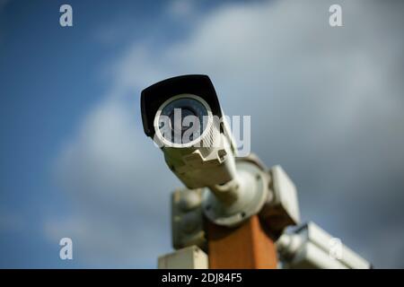 Videoüberwachungskamera. Sicherheitssystem des Territoriums. Überwachungskamera auf der Straße. Objektivglas für Videogeräte. Weiße Überwachungskamera. Stockfoto