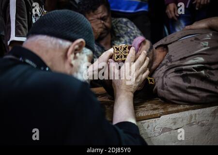KEINE WEB/KEINE APPS - der koptische Priester Pater Samaan Ibrahim führt am 19. August 2016 in der Kirche Saint Samaan (Simon), die auch als Höhlenkirche im Dorf Mokattam bekannt ist und den Spitznamen „Müllstadt“ trägt, in Kairo, Ägypten, eine Exorzismus-Sitzung durch. Einmal in der Woche versammeln sich Hunderte von Muslimen nach dem Gebet in der Kirche, um an einer Exorzismus-Sitzung des Priesters teilzunehmen. Mit einem Kreuz und heiligem Wasser kämpft er gegen spirituelle Wesen und Dämonen. Das Kloster hat ein Amphitheater mit einer Kapazität von 20,000 Sitzplätzen und ist damit die größte christliche Kirche im Nahen Osten. Es ist nach dem koptischen Heiligen SIM benannt Stockfoto