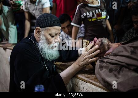 KEINE WEB/KEINE APPS - der koptische Priester Pater Samaan Ibrahim führt am 19. August 2016 in der Kirche Saint Samaan (Simon), die auch als Höhlenkirche im Dorf Mokattam bekannt ist und den Spitznamen „Müllstadt“ trägt, in Kairo, Ägypten, eine Exorzismus-Sitzung durch. Einmal in der Woche versammeln sich Hunderte von Muslimen nach dem Gebet in der Kirche, um an einer Exorzismus-Sitzung des Priesters teilzunehmen. Mit einem Kreuz und heiligem Wasser kämpft er gegen spirituelle Wesen und Dämonen. Das Kloster hat ein Amphitheater mit einer Kapazität von 20,000 Sitzplätzen und ist damit die größte christliche Kirche im Nahen Osten. Es ist nach dem koptischen Heiligen SIM benannt Stockfoto