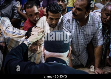 KEINE WEB/KEINE APPS - der koptische Priester Pater Samaan Ibrahim führt am 19. August 2016 in der Kirche Saint Samaan (Simon), die auch als Höhlenkirche im Dorf Mokattam bekannt ist und den Spitznamen „Müllstadt“ trägt, in Kairo, Ägypten, eine Exorzismus-Sitzung durch. Einmal in der Woche versammeln sich Hunderte von Muslimen nach dem Gebet in der Kirche, um an einer Exorzismus-Sitzung des Priesters teilzunehmen. Mit einem Kreuz und heiligem Wasser kämpft er gegen spirituelle Wesen und Dämonen. Das Kloster hat ein Amphitheater mit einer Kapazität von 20,000 Sitzplätzen und ist damit die größte christliche Kirche im Nahen Osten. Es ist nach dem koptischen Heiligen SIM benannt Stockfoto