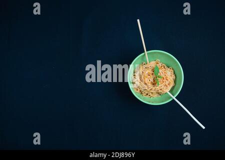 Hühnchen Schezwan Noodles oder Hakka oder Chow Mein in schwarzer Schale auf dunklem Hintergrund. Stockfoto