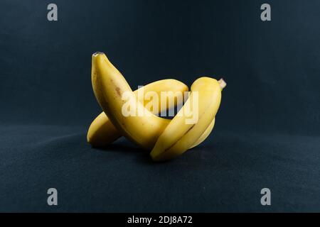 Gelbe Bananen auf schwarzem Hintergrund. Speicherplatz kopieren Stockfoto