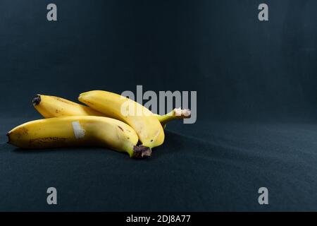 Gelbe Bananen auf schwarzem Hintergrund. Speicherplatz kopieren Stockfoto