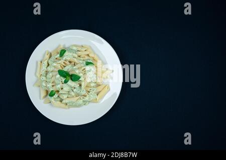 Pesto Penne Nudelgericht auf schwarzem Hintergrund Stockfoto