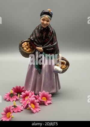 Eine vertikale Aufnahme einer alten Frau Porzellanfigur halten Körbe Stockfoto